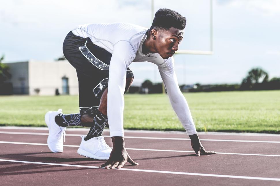 Free Image of Athlete preparing to start running on a track field 