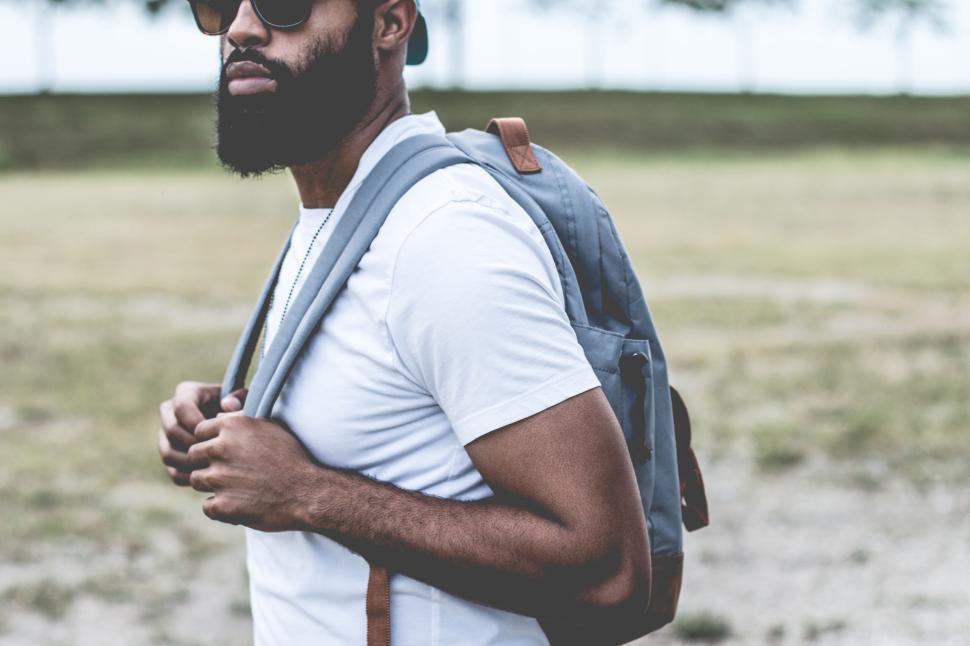 Free Image of Person carrying backpack wearing a white t shirt 