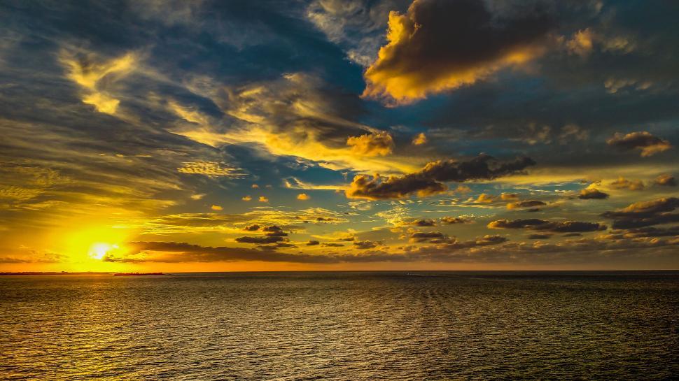 Free Image of Stunning ocean sunset with colorful cloud patterns 