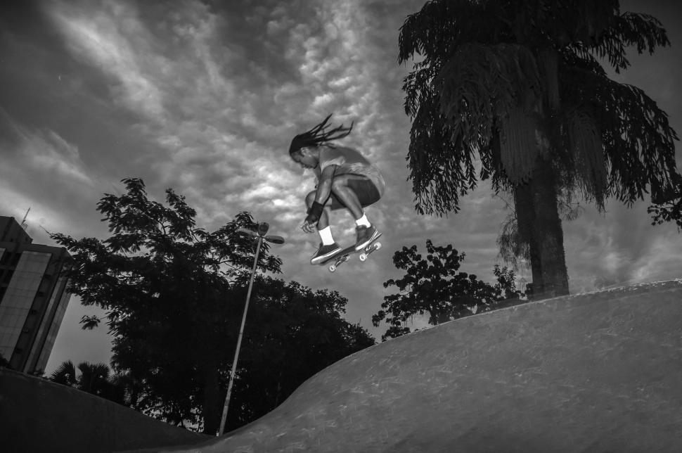 Free Image of Skateboarder mid-air trick at skate park in twilight 