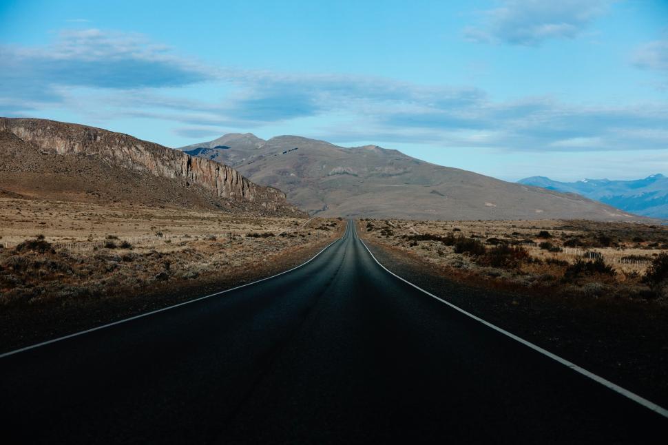 Free Image of Open road stretching towards distant mountains at dusk 