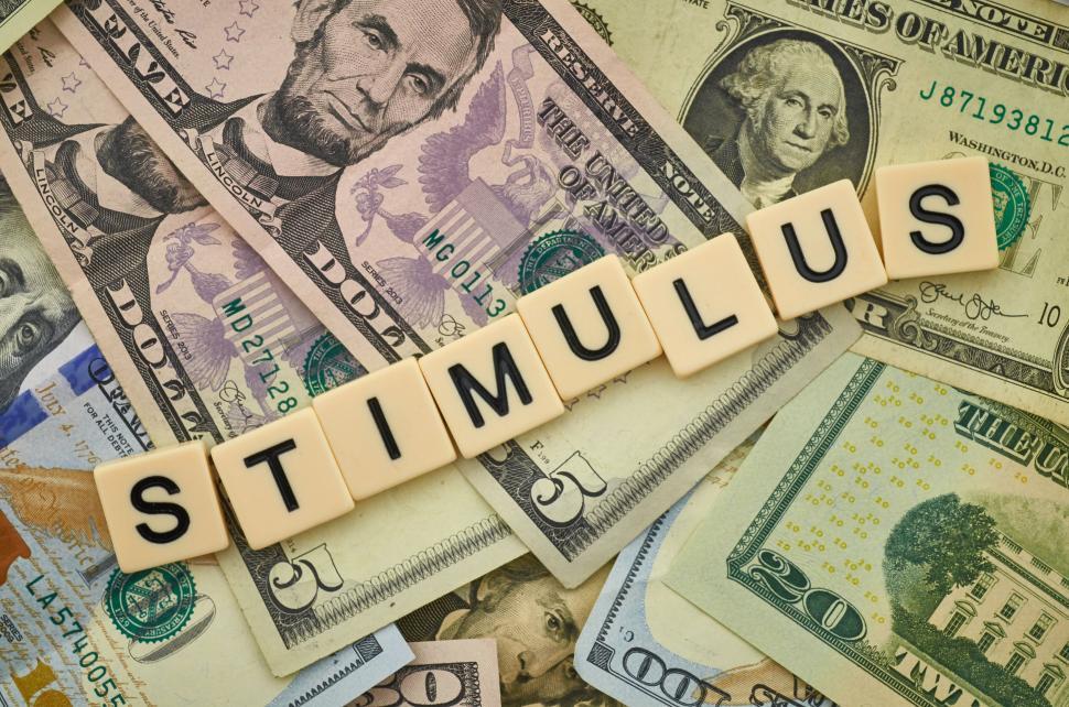 Free Image of Money and scrabble tiles spelling stimulus on a table 