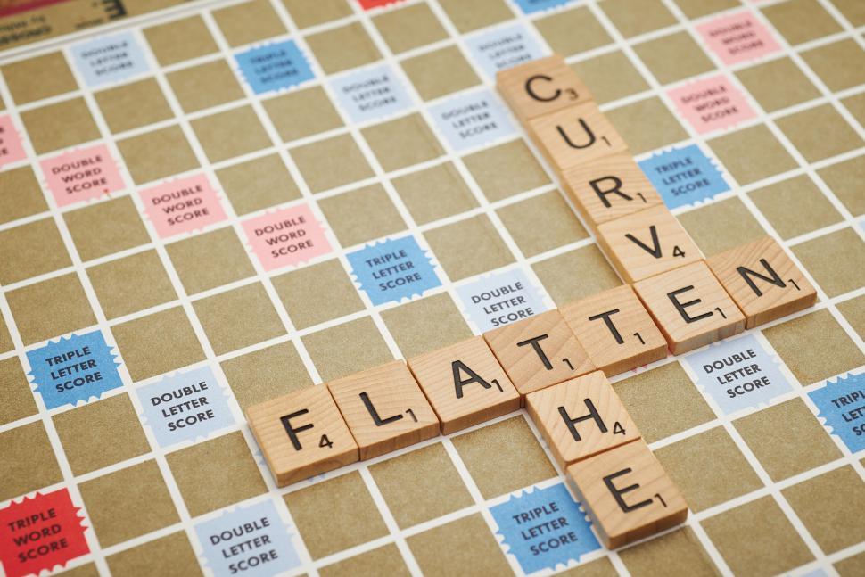 Free Image of Scrabble tiles spell  FLATTEN CURVE  on game board 