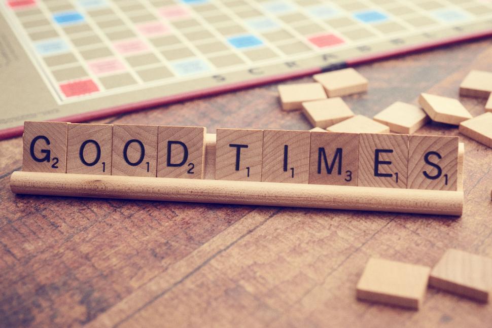 Free Image of Scrabble tiles spelling out  good times  on rack with board 
