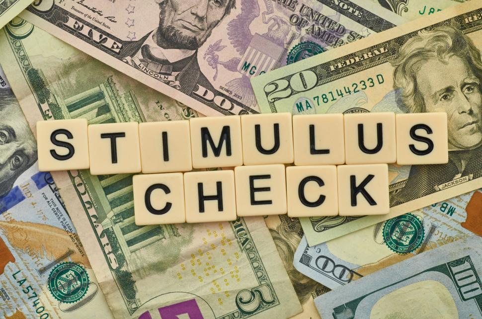 Free Image of Scrabble tiles spelling  stimulus check  on dollar bills. 