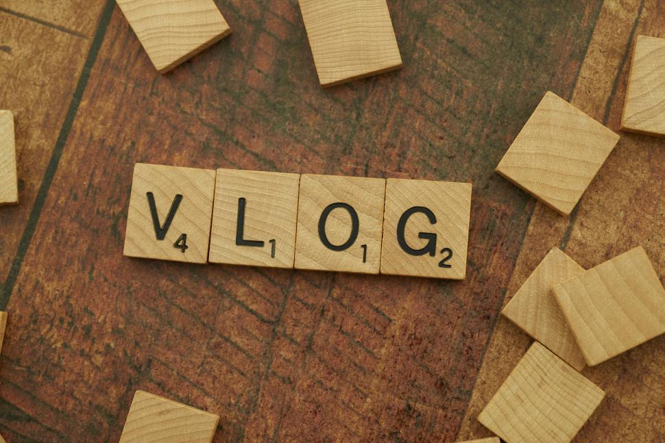 Free Image of Scrabble tiles spelling VLOG on a vintage wooden surface. 