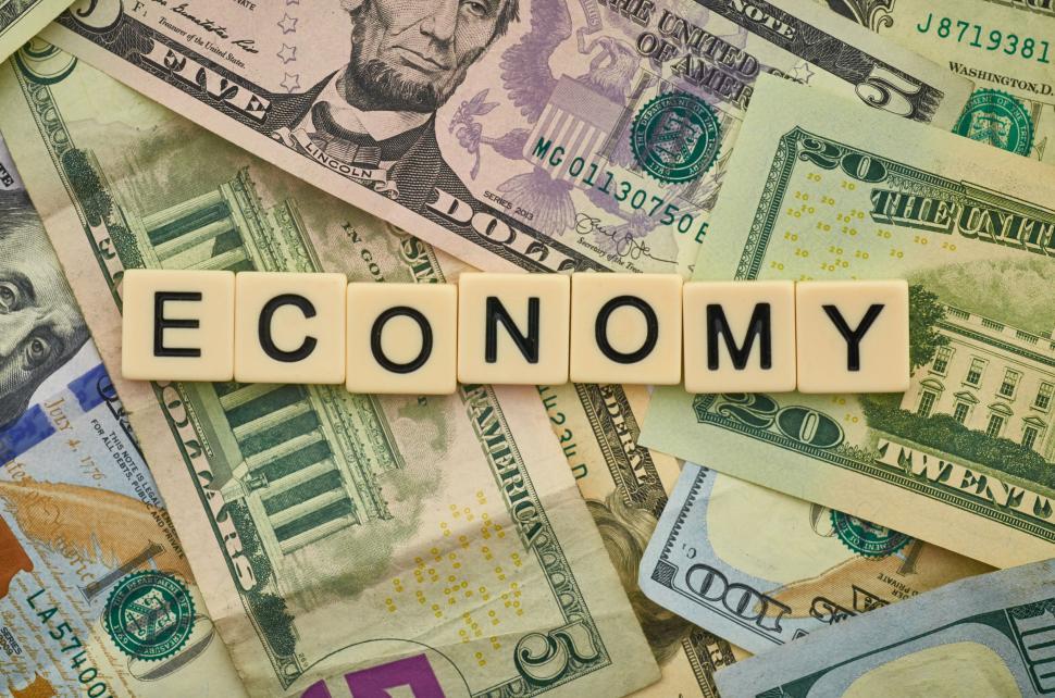 Free Image of Word ECONOMY spelled out with wooden tiles on money background 