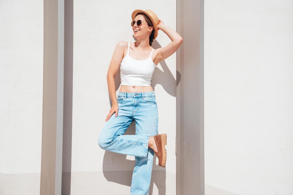 Free Image of Woman enjoying a sunny day in casual summer attire at a modern building in an urban area 