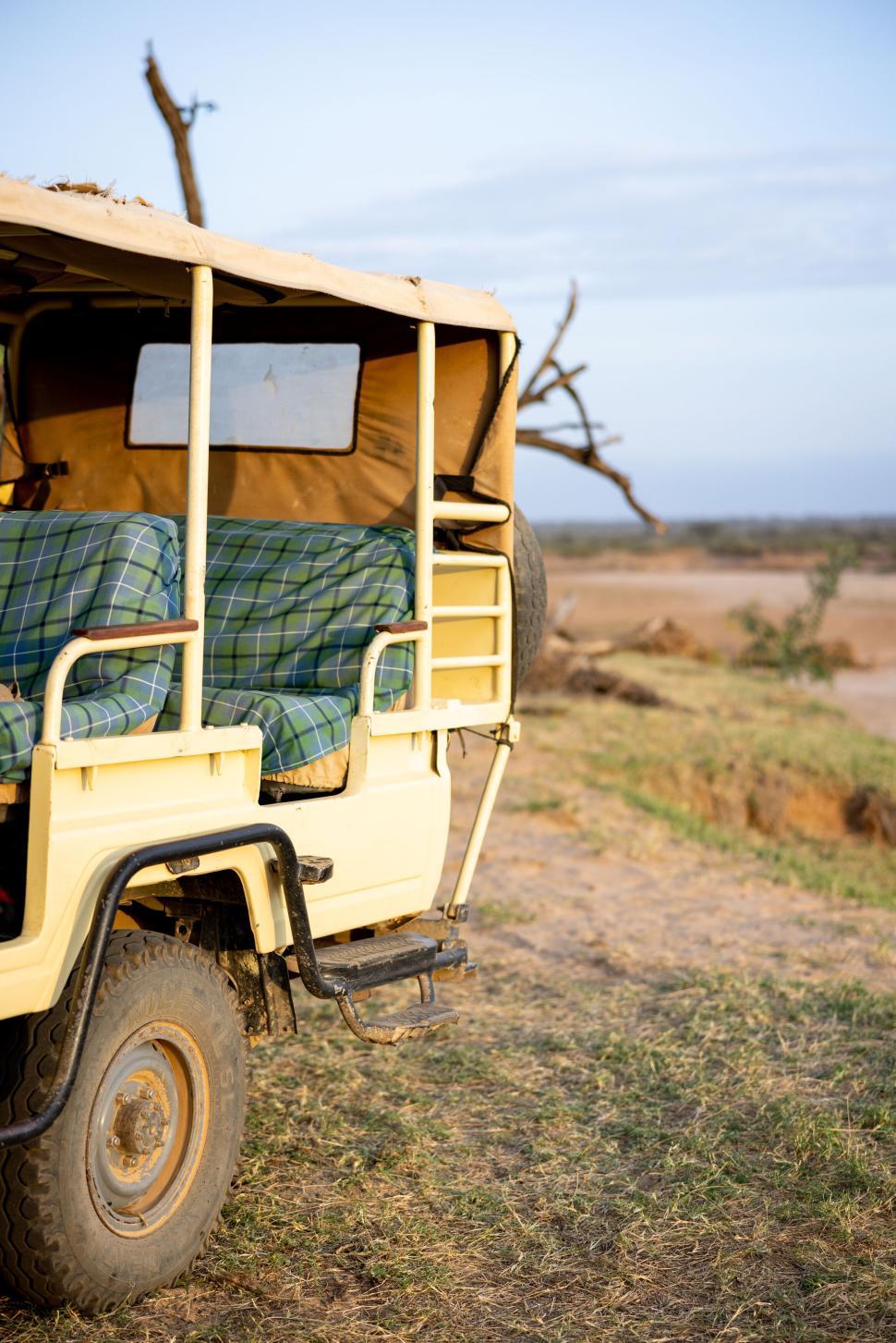Free Image of Safari vehicle parked on dry grassland under clear blue sky 