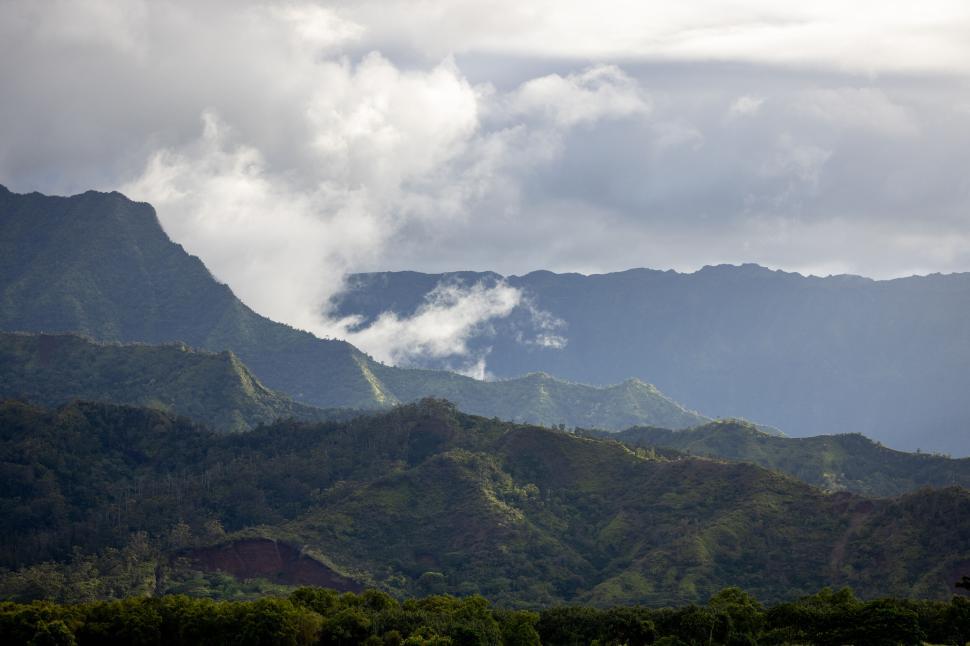 Free Image of Lush green mountainous landscape under cloudy sky 