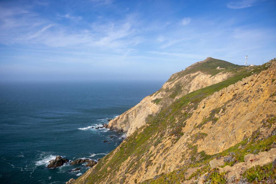 Free Image of Coastal cliffside landscape with clear blue sky 