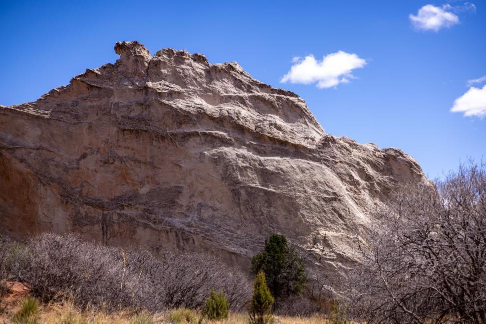 Free Image of Rocky mountain in a clear blue sky with dry desert floor 