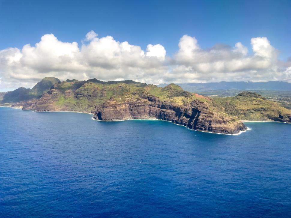 Free Image of Dramatic coastal cliffs meeting vibrant blue ocean waves. 