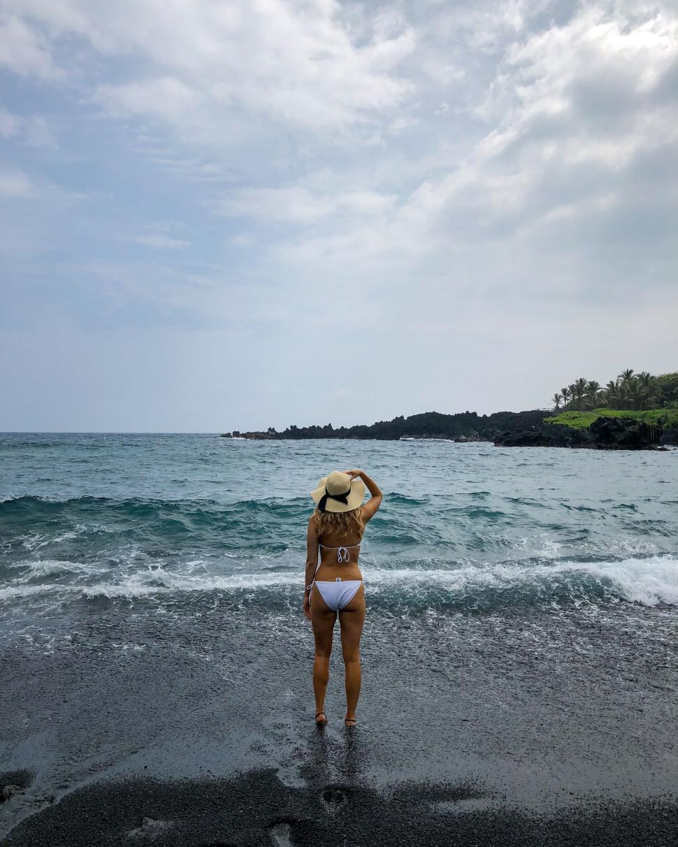 Free Image of Woman in bikini enjoying a day at the black sand beach 