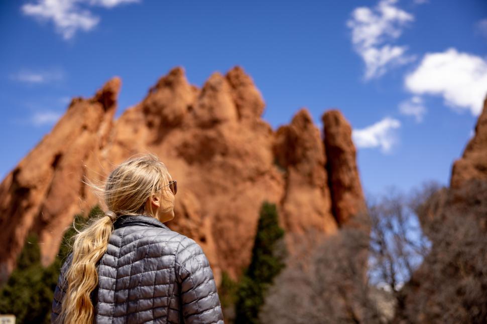 Free Image of Woman exploring a desert rock formation on a sunny day 