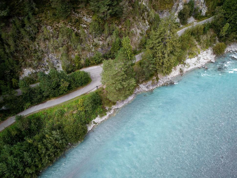 Free Image of Scenic path beside a pristine blue river 