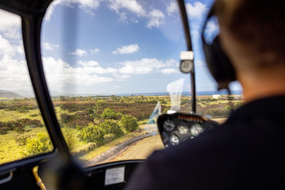 Free Image of Helicopter cockpit view of a lush green landscape 