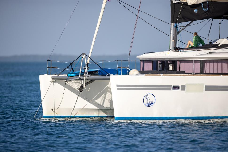 Free Image of Catamaran sailing on a serene blue ocean water body. 