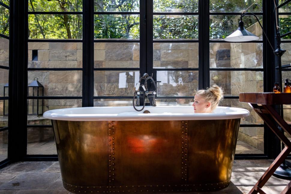 Free Image of Luxurious bath with warm lighting and natural view 