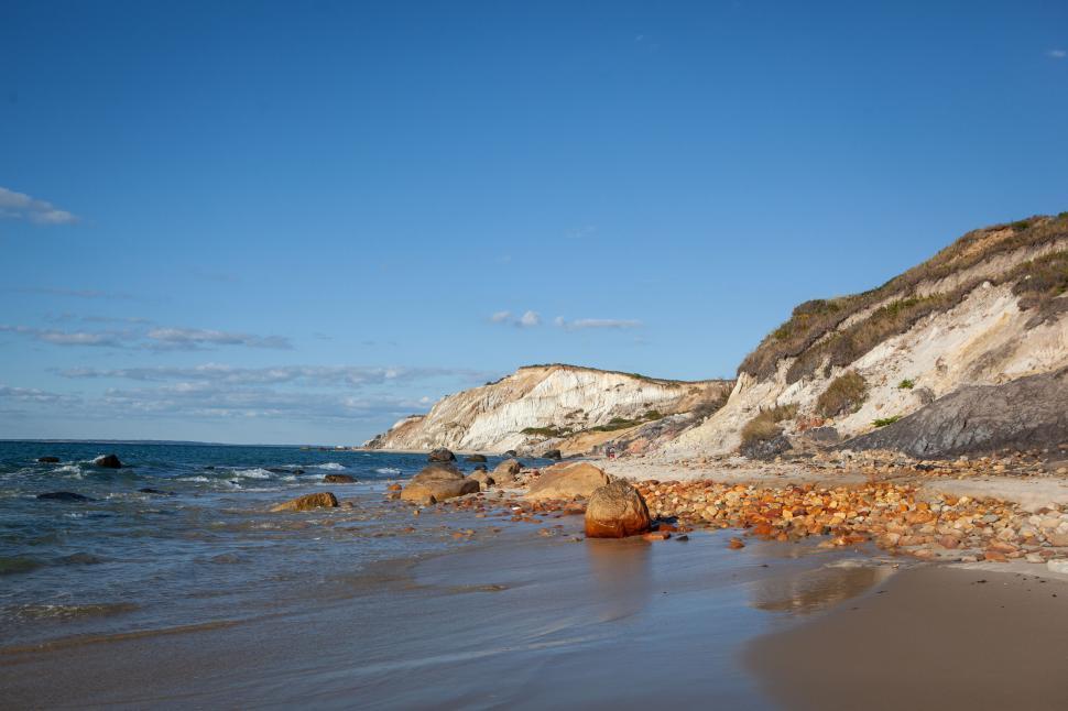 Free Image of Scenic coastal landscape with rocks and sandy shore. 