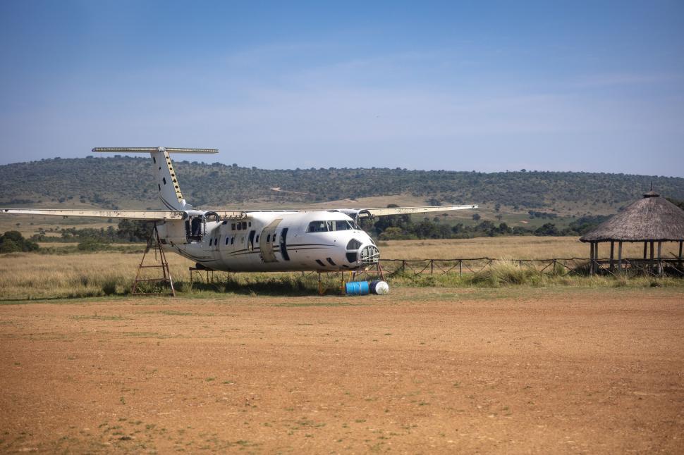 Free Image of Abandoned propeller plane in field with distant hills. 