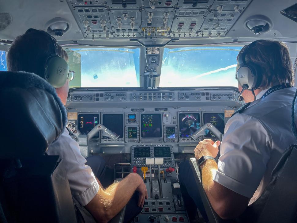 Free Image of Two pilots inside cockpit operating a commercial aircraft. 