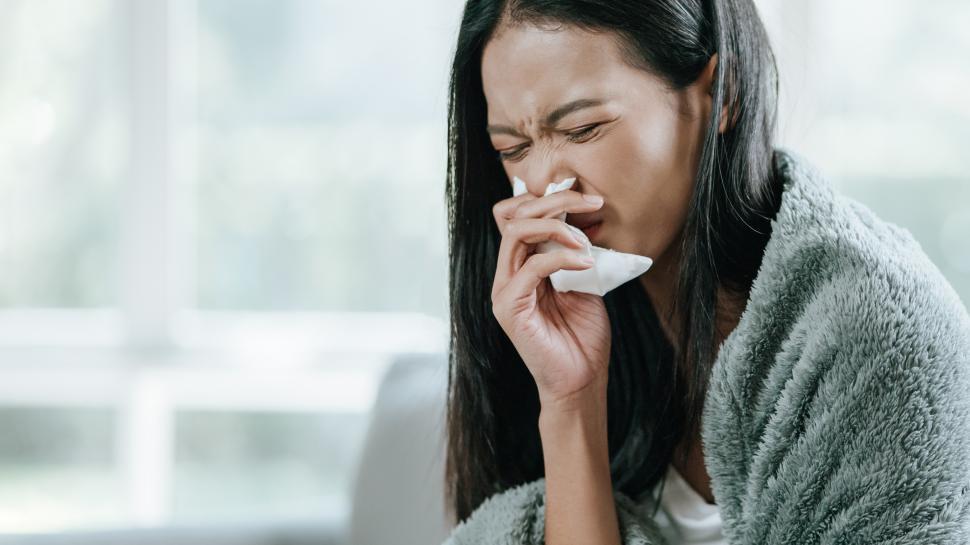 Free Image of Sick woman in warm wrap suffering from fever and flu on sofa 