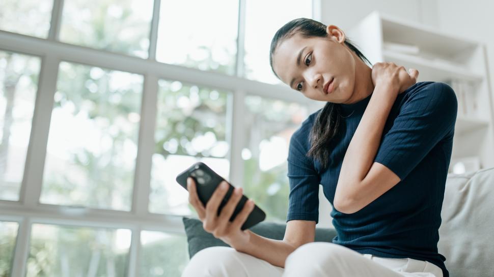 Free Image of Unhappy asian woman suffering from pain in the neck 