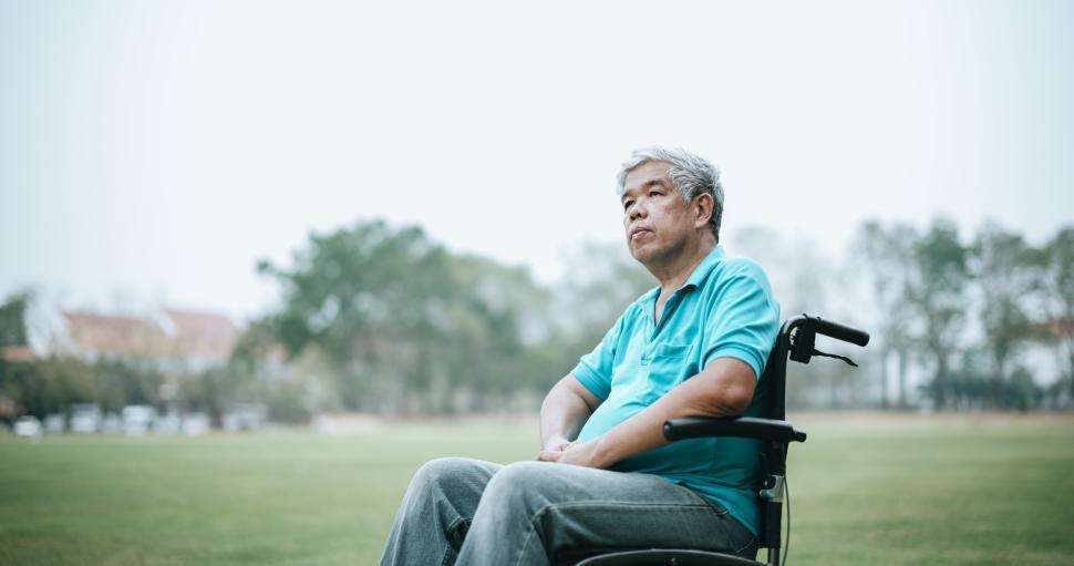 Free Image of Mature Asian man sitting on wheelchair relaxing in park 