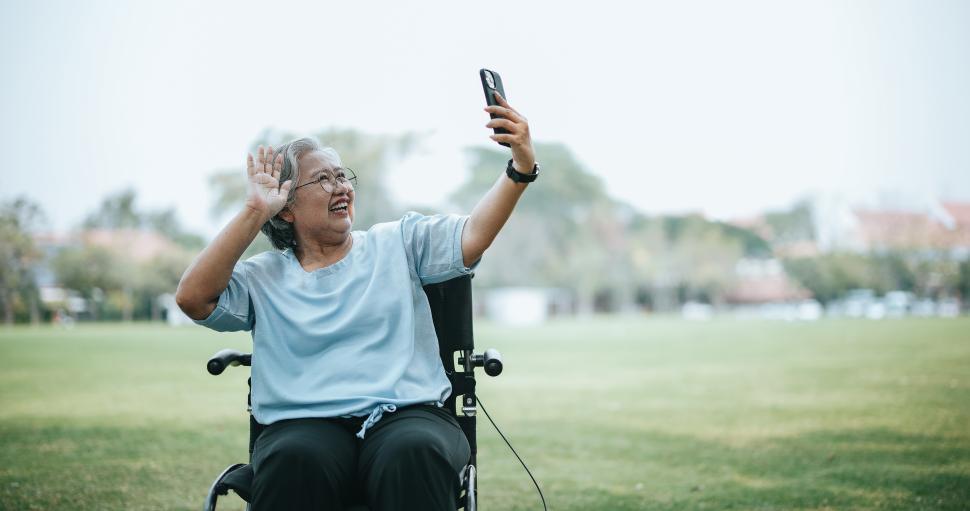 Free Image of Mature Asian woman on wheelchair use smartphone make video call 