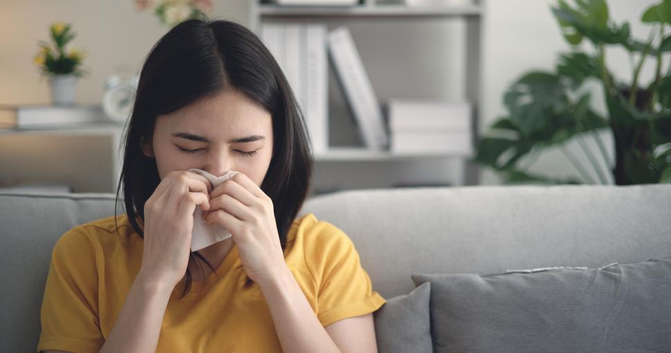 Free Image of Asian Young woman fever sneeze in blowing her nose in paper tissue at home 