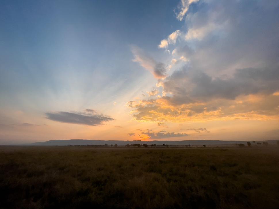 Free Image of Expansive landscape with golden sunset sky and clouds. 