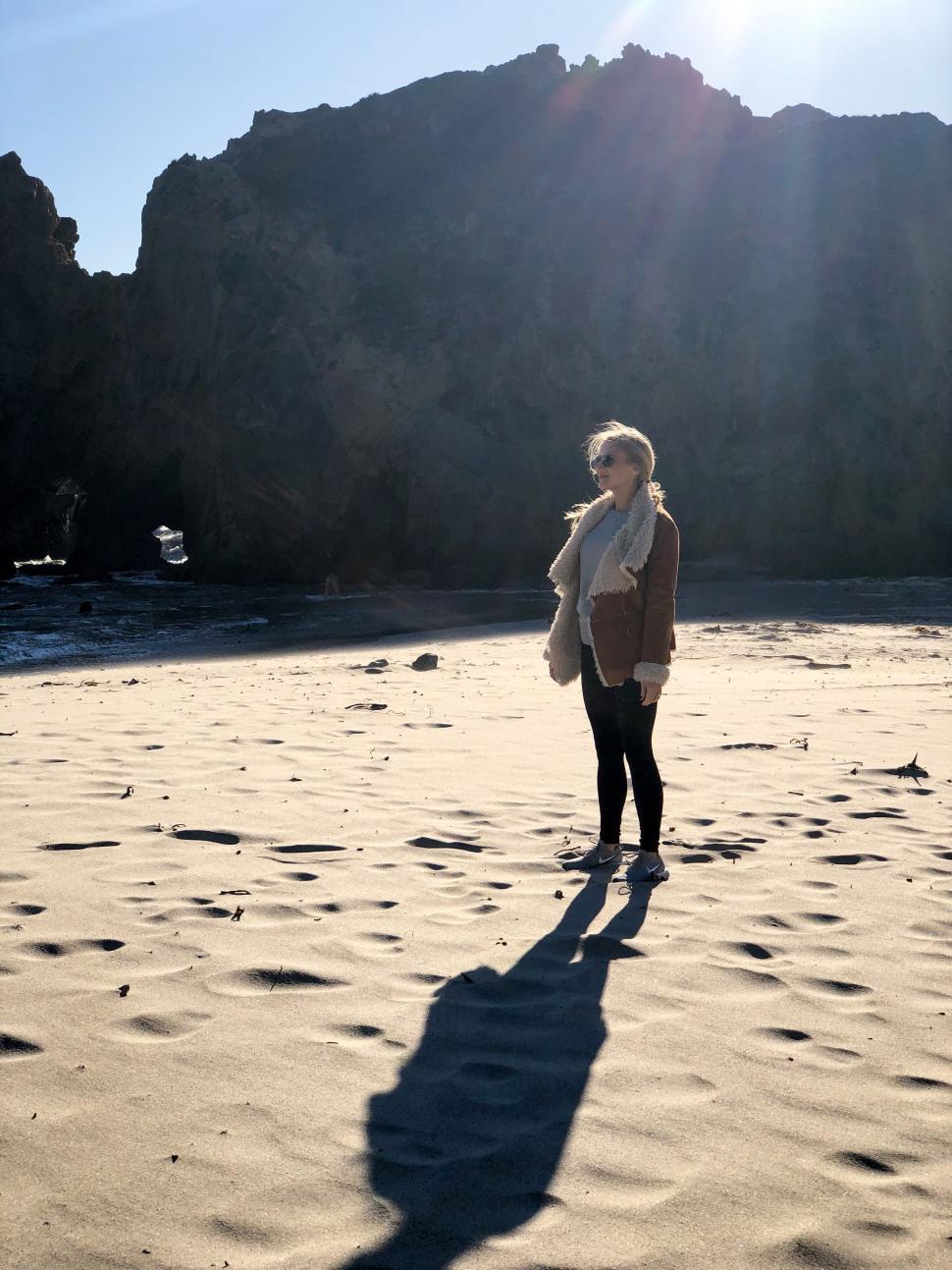 Free Image of Majestic beach at sunrise with towering rock formations. 
