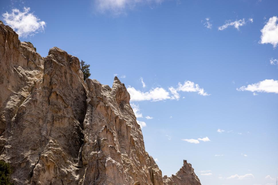 Free Image of Rocky cliffs under blue sky scattered with few clouds 