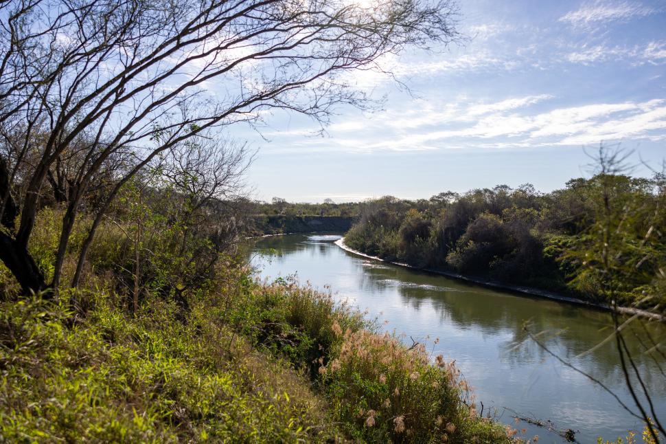 Free Image of Winding river through lush landscape with blue sky 