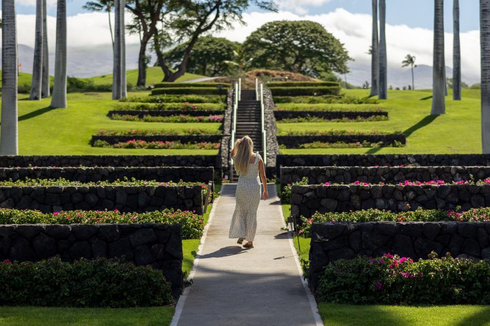 Free Image of Visitor wearing white dress in landscaped garden area 