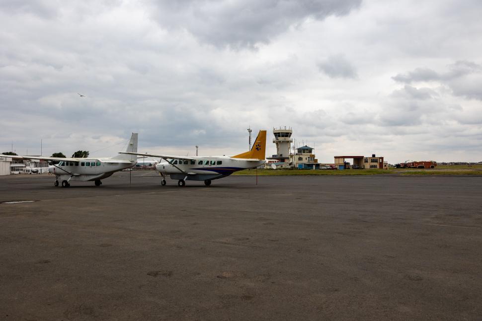 Free Image of Airport runway with small planes on a cloudy day 