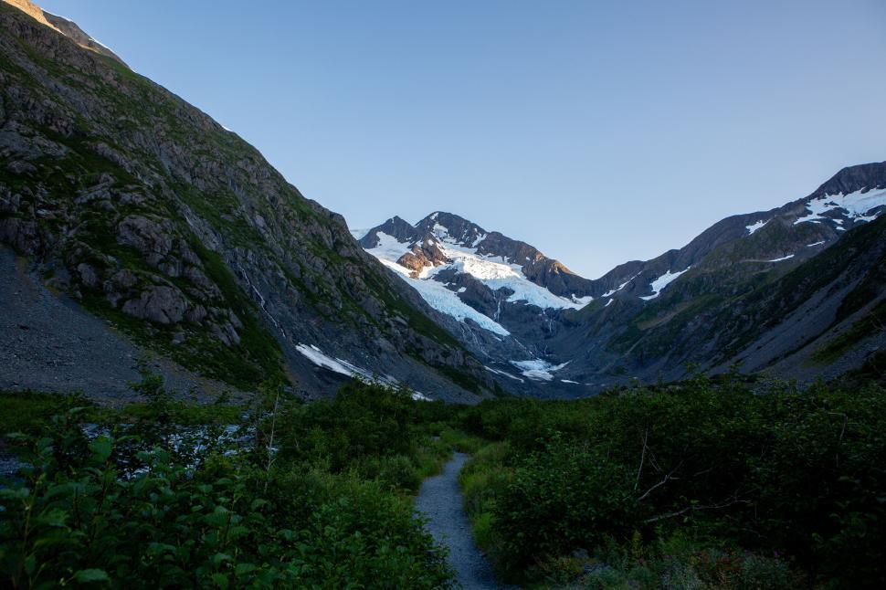 Free Image of Mountain valley featuring a glacier on a sunny day 