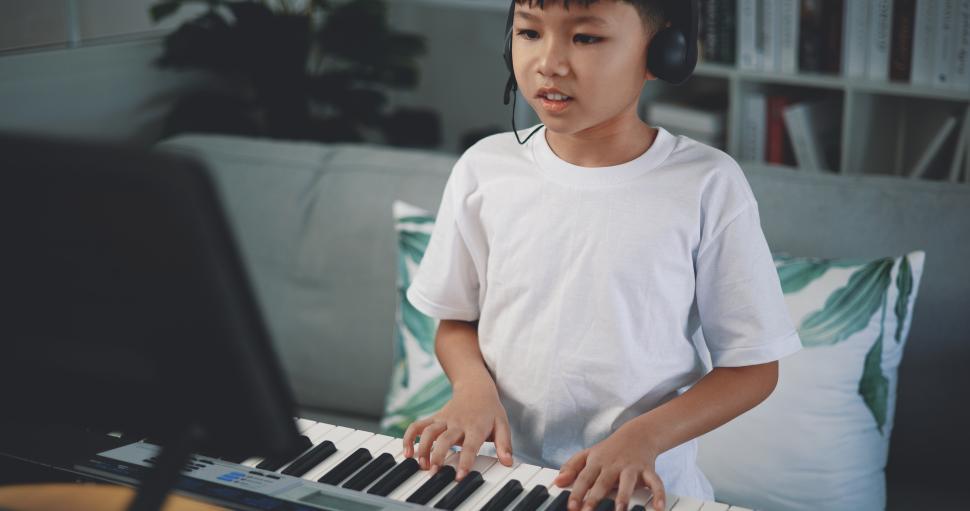 Free Image of Cute boy enjoy to learning playing piano at home 