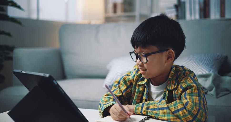 Free Image of Asian genius boy use tablet doing homework in living room 