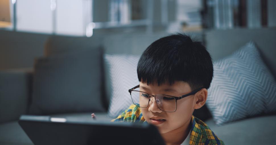 Free Image of Asian genius boy use tablet doing homework in living room 