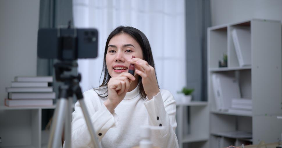 Free Image of Asian woman blogger shows how to make up cosmetics at home 
