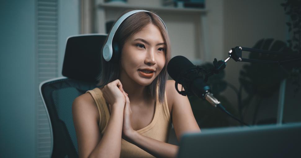 Free Image of Cheerful Young podcaster use microphone during online podcast in studio 