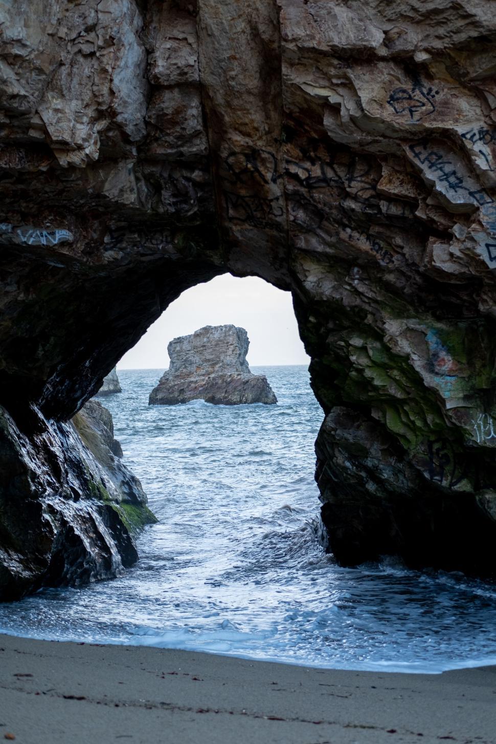 Free Image of Rocky ocean cave with a view of sea stack and water 