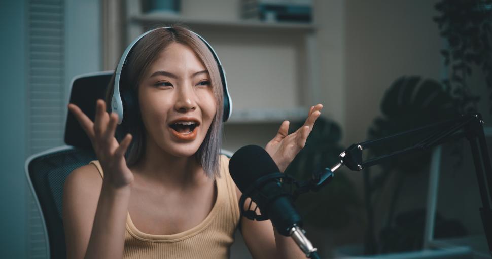 Free Image of Cheerful Young podcaster use microphone during online podcast in studio 