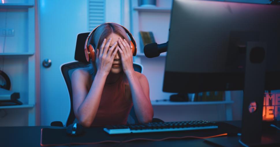 Free Image of Asian young Esport woman gamer play online game on PC feel upset 