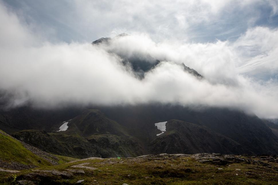 Free Image of Cloudy mountain with mist surrounding the peak landscape 