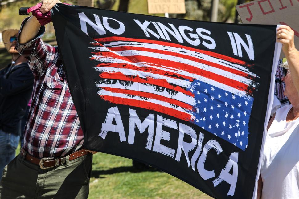 Free Image of Political protest in United States against Donald Trump featuring a flag stating no kings in America 