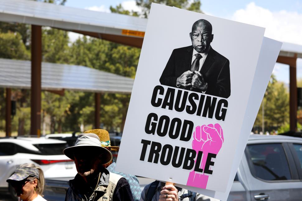 Free Image of Causing Good Trouble sign at a political protest against Donald Trump focusing on activism and social justice in the United States 