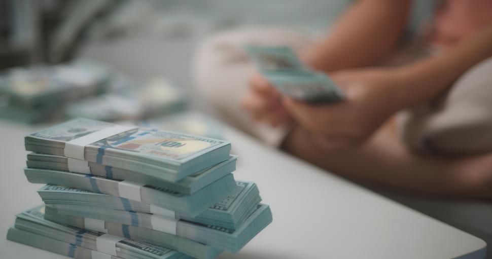 Free Image of Portrait close up of young asian woman counts cash dollar bills while sitting in living room at home,counting stack cash money dollar, Financial planning. 